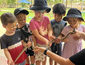 ELC students holding a snake.